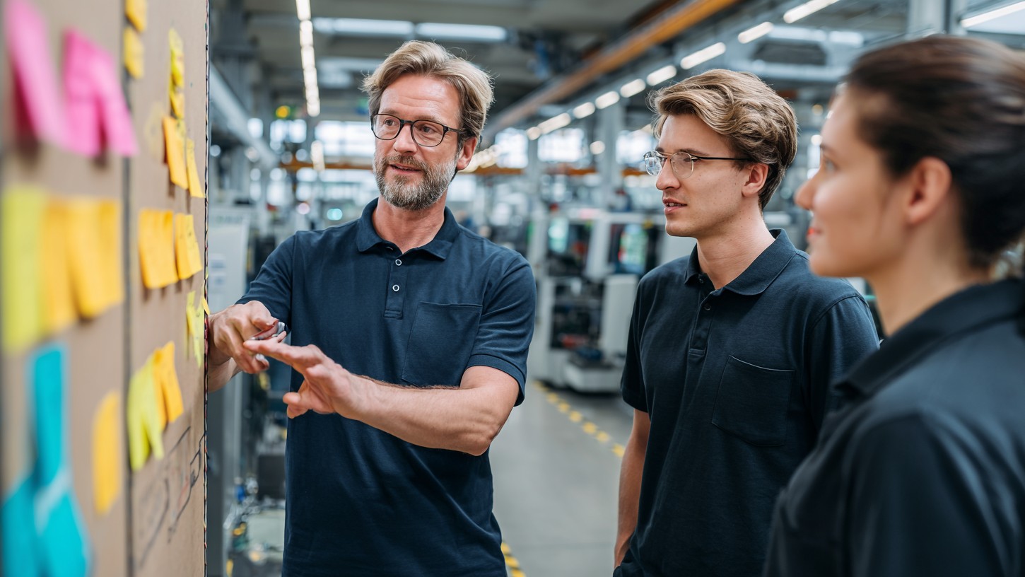 Team im Austausch am Verbesserungsboard